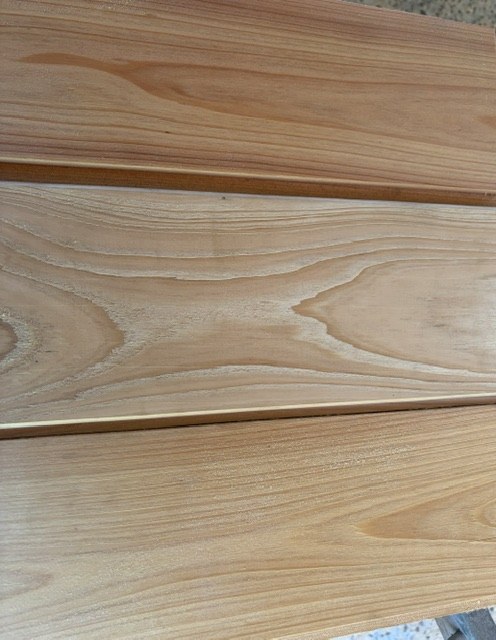 Planed cypress shiplap boards laid side by side showing the overlap